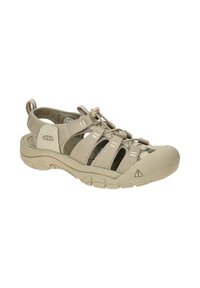 Beige outdoor sandal featuring a rubber toe cap, textured straps, and elastic lacing system. Durable, non-slip sole with traction details.