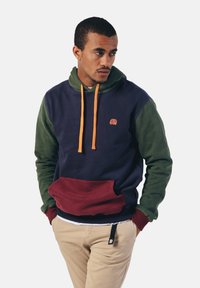 Hoodie in navy, groen en bourgondië. Voorzien van oranje trekkoorden, een voorzak en een klein geborduurd olifantenlogo. Gemaakt van een katoenmix.