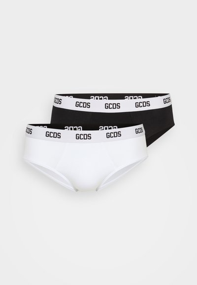 Two pairs of GCDS underwear: one white and one black, both with a contrasting waistband featuring the brand logo in white.
