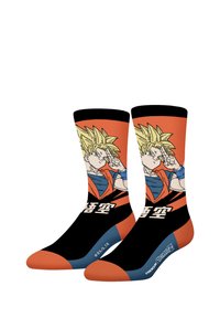 Chaussettes noires et orange ornées d'une illustration d'un personnage avec des cheveux blonds en piques et une tenue bleue, avec du texte noir dans la partie inférieure.