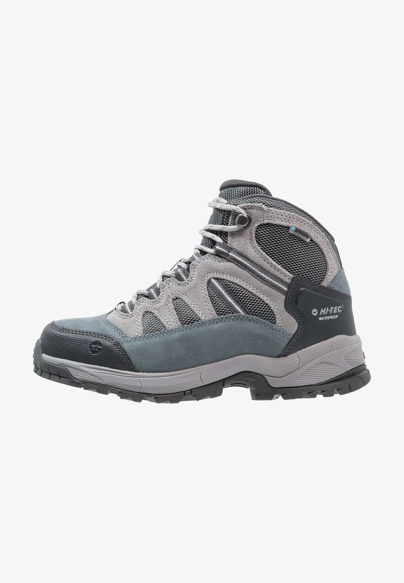 Scarpa da trekking grigia realizzata con una combinazione di materiali in suede e mesh, suola in gomma testurizzata e occhielli metallici per una vestibilità sicura.