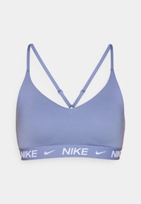 S sujetador deportivo Nike en lavanda clara con una textura suave, tirantes ajustables y un logo blanco en la banda elástica. Diseño clásico.