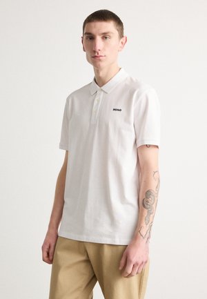 Weißes Polohemd mit einer dreiknöpfigen Knopfleiste und gesticktem schwarzen "HUGO"-Logo. Kurze Ärmel und weicher Baumwollstoff. Hosen in neutralen Farben.