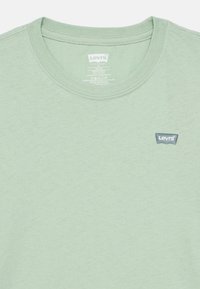 Φωτεινό πράσινο t-shirt Levi's με στρογγυλή λαιμόκοψη. Διαθέτει ένα μικρό μπλε έμβλημα λογότυπου στο στήθος. Μαλακό, υφασμένο βαμβακερό υλικό.