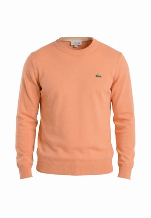 Pull à manches longues pour homme de couleur pêche avec col rond, logo Lacoste sur le côté gauche de la poitrine, poignets et ourlet côtelés.