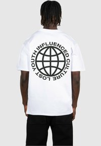 T-shirt en coton blanc à manches courtes, présentant un grand graphisme noir d'un globe et le texte "LA CULTURE INFLUENCÉE PAR LA JEUNESSE PERDUE" au dos.