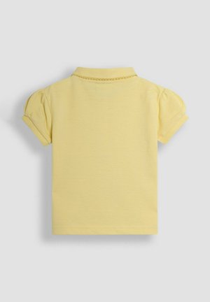 Keltainen lyhythihainen poloshirt, jossa on kaulus, puffihihat ja teksturoitu kudos. Takakatsaus ei näytä lisätietoja.