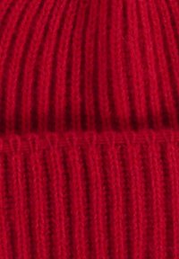 Rode gebreide beanie met verticale ribbels, gemaakt van wol. Beschikt over een gestructureerde afwerking en een comfortabele pasvorm, ideaal voor warmte.