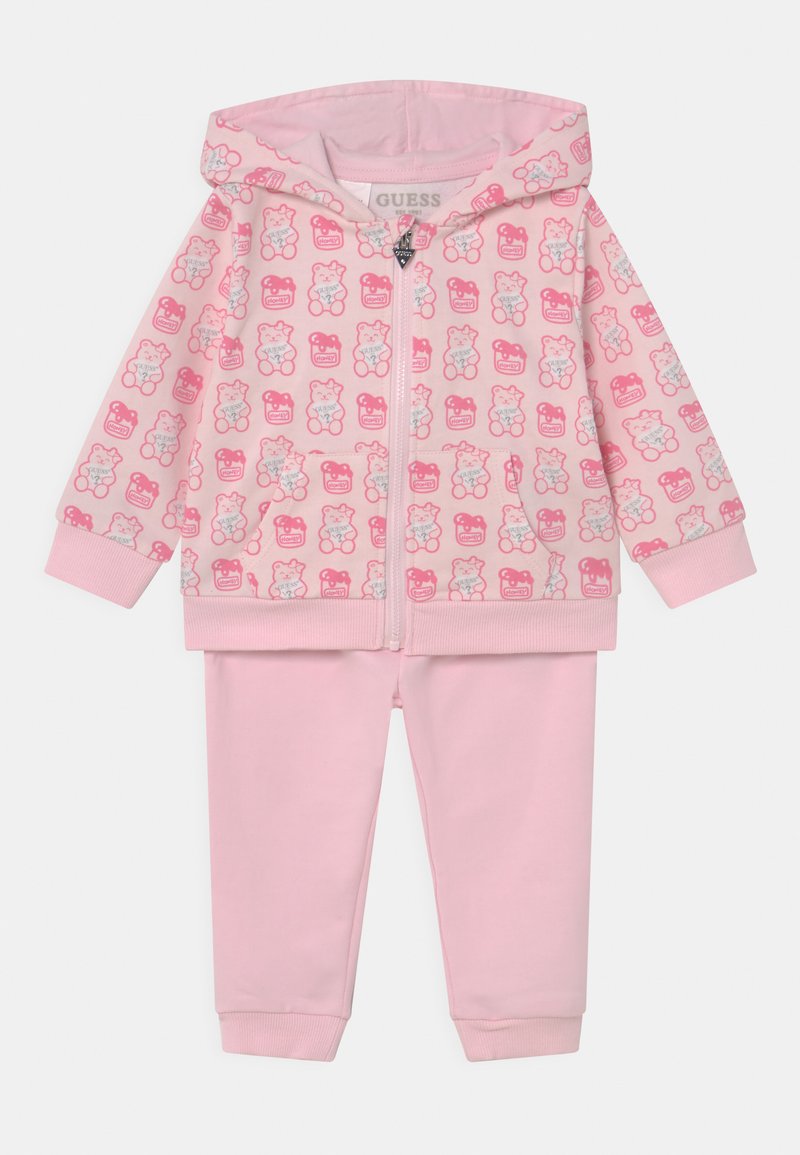 Felpa rosa con zip decorata con motivi di orsetti, abbinata a pantaloni rosa coordinati. Tessuto morbido e liscio con polsini e vita a coste.
