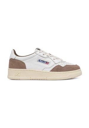 Zapatilla blanca de perfil bajo con detalles en piel de ante beige, puntera perforada, suela crema y parche con el logo y la bandera americana en el panel lateral.