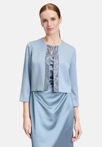 Jasnoniebieska krótka kurtka z rękawami do łokci, z zapięciem ozdobionym cekinami i gładką, satynową fakturą.