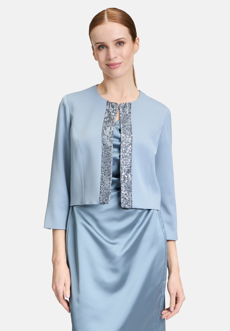Jasnoniebieska krótka kurtka z rękawami do łokci, z zapięciem ozdobionym cekinami i gładką, satynową fakturą.