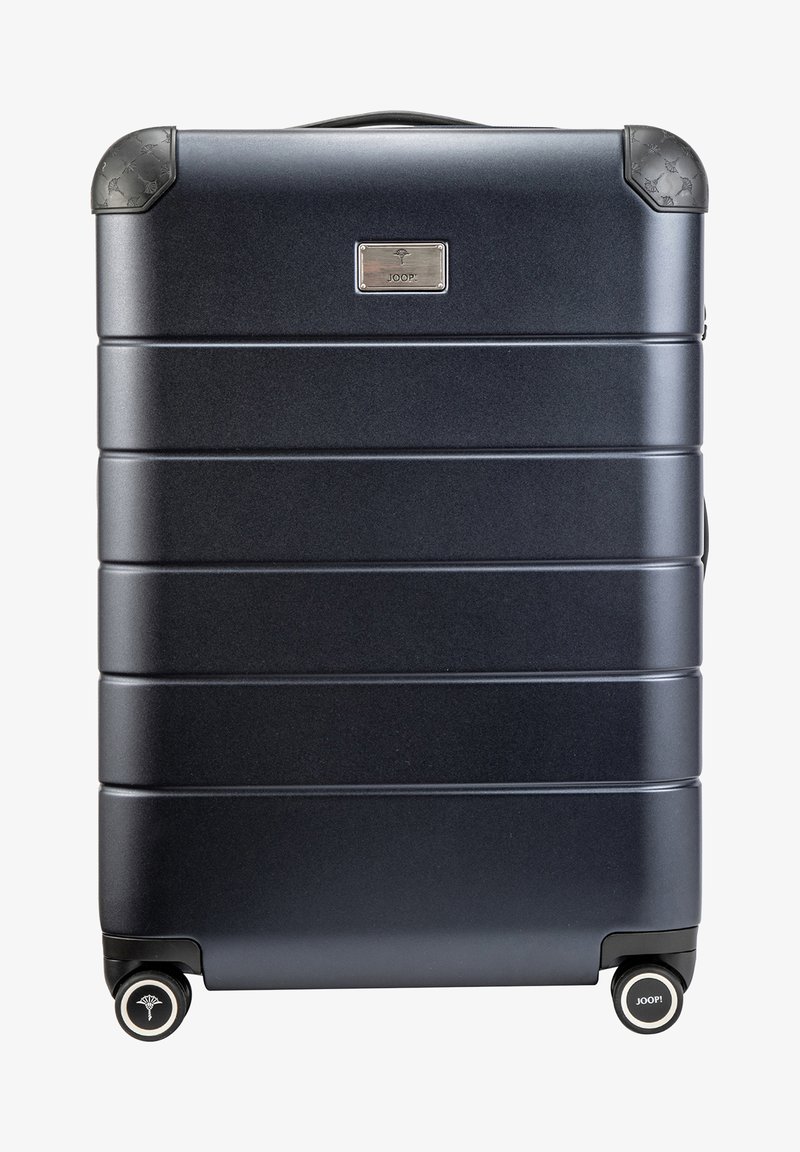 Valise rigide bleu foncé avec texture rainurée, coins arrondis, roues doubles et plaque logo. Deux poignées pour un transport facile.