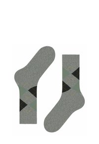Un paio di calzini grigi con un motivo a rombi argyle verde, nero e giallo nell'area del polpaccio, distesi piatti e rivolti in direzioni opposte.