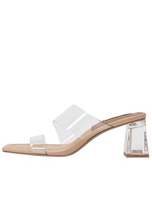 Clear hæle-sandaler med en gennemsigtig PVC-overdel, beige fodseng og en firkantet, akryl blokhæl. Har et minimalistisk design og glat tekstur.