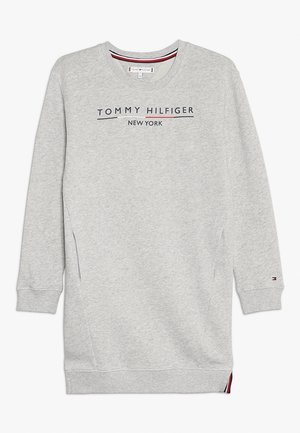 Sweatshirt gris à manches longues, col rond et poches latérales. Présente le texte "TOMMY HILFIGER NEW YORK" en bleu marine avec des accents rouges.
