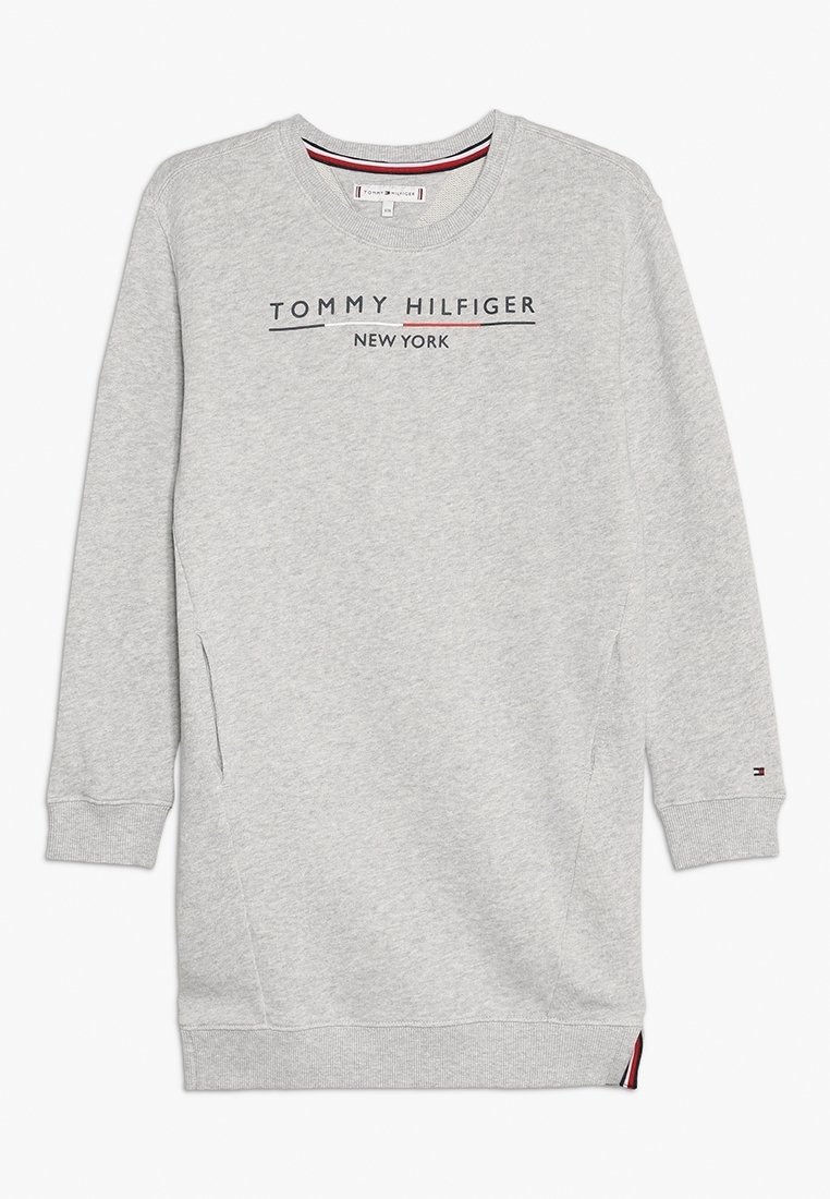 Harmaa huppari pitkillä hihoilla, pyöreällä kaula-aukolla ja sivutaskuilla. Varustettu tummansinisellä ja punaisella korostuksella "TOMMY HILFIGER NEW YORK" -tekstillä.