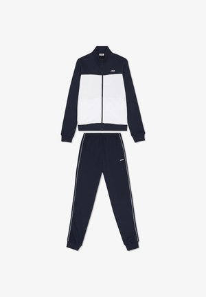 Chándal FILA en azul marino y blanco con chaqueta con cremallera y pantalones de cintura elástica con rayas blancas laterales y logo en el pecho y el muslo.