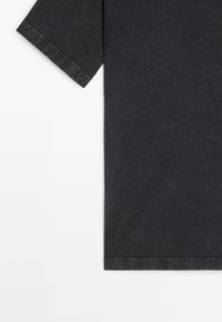 T-shirt a maniche corte grigio scuro con colletto rotondo e orlo cucito. Realizzato in tessuto misto cotone con una consistenza morbida.
