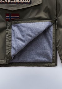 Žalia išorinio džinsinio audinio striukė su šviesiai pilku flisinio pamušalu. Yra užtrauktukas ir mažas Norvegijos vėliavos užrašas.