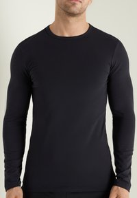 Langarmshirt aus schwarzem Stoff, Rundhalsausschnitt, taillierte Passform, glatte Textur, ohne sichtbare Muster oder Verzierungen.