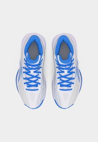 Ζευγάρι λευκών αθλητικών παπουτσιών με μπλε κορδόνια και εσωτερική επένδυση, σε θέα από πάνω πάνω σε απλό λευκό φόντο.