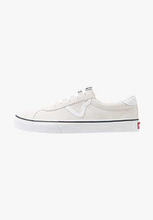 Baskets en suède blanc avec des accents noirs, lacets blancs et semelle en caoutchouc. Présente un logo brodé et un contour noir le long du bord de la semelle.