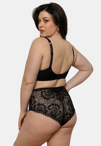 Ensemble de lingerie en dentelle noire comprenant un soutien-gorge non rembourré avec des bretelles réglables et une culotte taille haute ornée de motifs en dentelle florale.