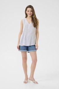 Haut sans manches blanc avec des rayures verticales, design à col en V, associé à un short en denim avec ourlet roulé. Modèle portant des sandales à talons blocs de couleur claire.