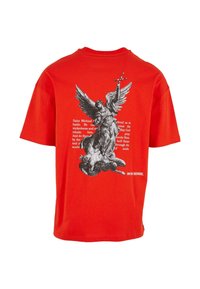 Rød bomulls T-skjorte med svart grafikk av Saint Michael og tekst på baksiden. Korte ermer og rund hals. Enkelt design.