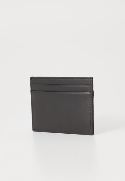 Porte-cartes en cuir noir avec texture lisse, comportant plusieurs emplacements pour cartes et un design minimaliste. Bords soigneusement piqués, forme compacte.