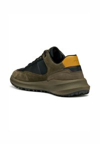 Baskets pour hommes en mélange de daim et de textile dans des tons de vert olive et noir, avec une semelle en caoutchouc et un accent de talon jaune contrastant.