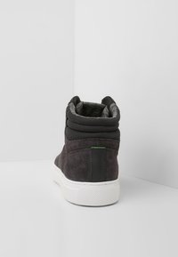 Hochschaft-Sneaker aus dunkelgrauem Wildleder und Mesh. Mit gepolstertem Kragen, schwarzen Lederakzenten und einer weißen Gummisohle.
