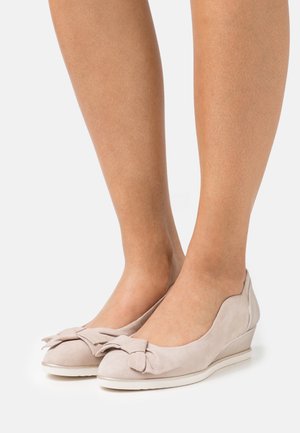 Lyse beige kilehæle lavet af blødt suede, med en båndsløjfe accent på tåen og en glat, rund form.