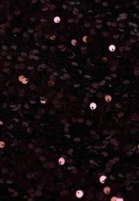 Tissu bordeaux recouvert de sequins ronds brillants, présentant un mélange de teintes réfléchissantes sombres et claires, créant une surface texturée et scintillante.