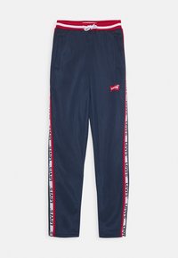 Navy Jogginghosen mit rotem elastischen Bund, weißem Kordelzug, Seitentaschen und roten Seitenstreifen mit wiederholtem "Levi's" Branding.