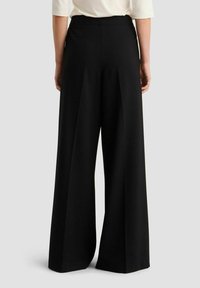 Zwarte wijde broek met een gladde textuur en een hoge taille. Heeft plooien aan de voorkant en een getailleerde pasvorm aan de achterkant.
