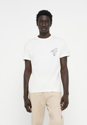 Witte katoenen t-shirt met korte mouwen en een ronde hals, met een zwart gedrukt logo op de linkerkant van de borst. Fijne textuur.