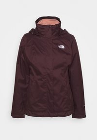 Donkerrode waterdichte jas met een hoge kraag, ritssluitingen en een logo op de borst. Ontworpen met een zachte voering en een tweekleurige uitstraling.