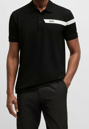 Schwarzes Poloshirt aus glattem Stoff, mit weißem Streifen und Logo auf der Brust, klassischem Kragen und kurzen Ärmeln.