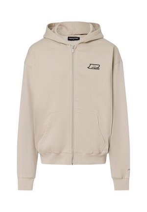 Sudadera con cremallera en color beige, hecha de algodón, con un bolsillo tipo canguro, puños de canalé y un pequeño logo en el pecho. Textura suave.