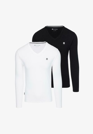Trička s dlouhým rukávem ve tvaru v-krku v bílé a černé barvě. Vyrobena z bavlny, má úzký střih a malé logo na hrudi. Velikost M.