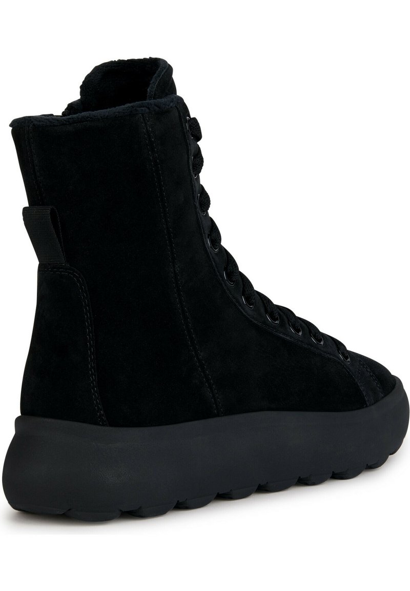 Botín negro de ante hasta el tobillo con superficie texturizada, puntera redonda, cierre con cordones en la parte delantera y suela de goma gruesa para mayor amortiguación.