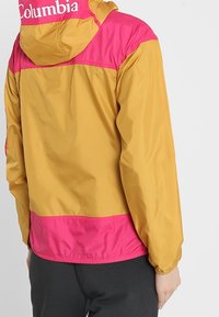 Giacca a vento gialla e rosa con cappuccio, caratterizzata da polsini elasticizzati, vita con cordino e logo "Columbia" sul retro.