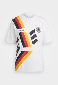 Λευκό T-shirt Adidas με μαύρες, κόκκινες και κίτρινες διαγώνιες ρίγες και το λογότυπο του Deutscher Fußball-Bund στο στήθος.
