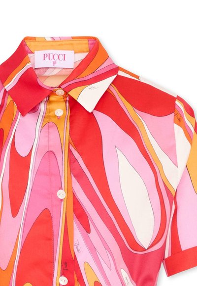 Chemise à col boutonnée avec un motif abstrait de tourbillons en rouge, rose, orange et blanc, manches courtes.