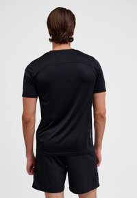 Zwarte sport T-shirt, korte mouwen, gladde stof, licht getailleerd ontwerp. Eenvoudige stiksels langs de schouders en de nek.