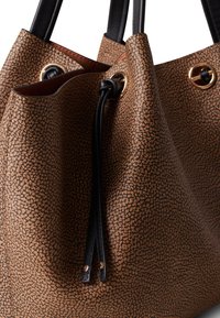 Borsa a secchiello in pelle marrone testurizzata con dettagli neri, dotata di hardware color oro, chiusura con coulisse e due manici in pelle nera.