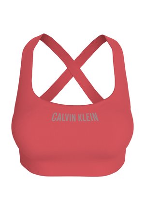 Brassière de sport rouge avec bretelles croisées au dos et logo "Calvin Klein" imprimé en gris sur le devant.