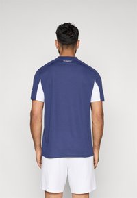 Tumed sinine sportlik särk lühikeste valgete varrukatega, ümarate kaelustega ja sujuva tekstuuriga, loodud jõudluseks ja mugavuseks.